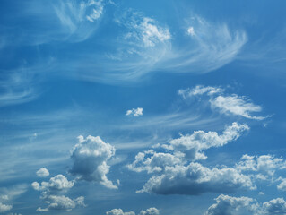 Wall Mural - Some light cumuliform and cirrus clouds in the clean blue sky.