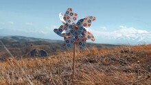 Paper Spinner Rotates Against The Sky And Mountains Day