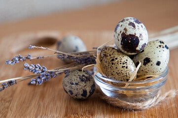 
quail eggs on a light beige background on a wooden board