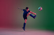 © master1305 - Teen male football or soccer player on gradient background in neon light. Caucasian expressive boy training, practicing on the run, in jump. Concept of sport, competition, winning, motion, action.