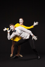 Man Mime Talking On Mobile Phone And Woman Mime Standing With Him On Isolated Black Background 