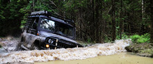 Extreme Driving, Challenge And 4x4 Vehicles Concept. Offroad Race In Forest. SUV Or Offroad Car. Car Rides In A Deep Puddle
