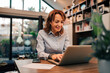 © bnenin - Cheerful businesswoman typing on laptop at home office, portrait.