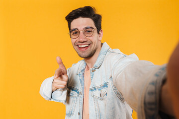 Poster - Photo of delighted bristle man pointing finger at camera while taking selfie photo