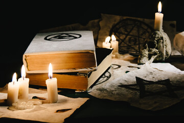 Occult grimoire, magic book laying on table with occult symbols, candles, pentagrams, fortune telling, ritual, altar, spiritism, secret knowledge, scull