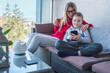 © Andrii IURLOV - Stay at home mom. Mother and son spend free time on terrace. Woman working, child using smartphone. Weekend Family. Bonding concept.