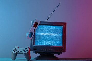 Wall Mural - Antenna old-fashioned  tv receiver with anaglyph stereo glasses, gamepad in pink blue gradient neon light. Retro media, entertainment 80s, retro wave