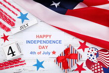 Text Happy Independence Day With Flag, Gift Box And Cube Calendar On White Wooden Background