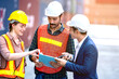 © ftgstudio - Industrial worker working at cargo freight logistic warehouse for import export, foreman team meeting and brainstorm , Import and export business.