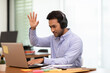 © 220 Selfmade studio - Young business indian man meeting with business team via video conference call at Home,Hand up Greetings with group in online video call