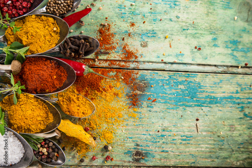 Photo Various colorful spices on wooden table, top view.