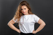 © Photodrive - Mad woman portrait. Protest conflict. Angry lady with hands on hips isolated on gray background.