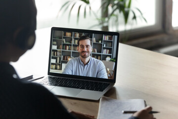 Sticker - Girl trainee learn language wear headphones view over her shoulder laptop screen where male tutor share knowledge smile looks at camera. Colleagues work distantly using video call and computer concept