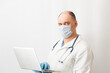 © Aleksey Khripunkov - Doctor in mask working with laptop. Telemedicine. Computer technology in medicine