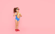 © oes - Little child girl in sunglasses in a bathing suit resting on a pink background. Summer rest concept