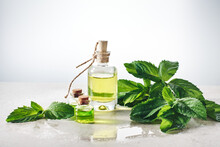 Peppermint Essential Oil And Fresh Mint Leaves.