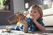 © New Africa - Little boy playing with cardboard helicopter on floor at home. Creative hobby
