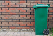 Plastic Container For Collecting  Garbage Near Red Brick Wall. Copy Space. 