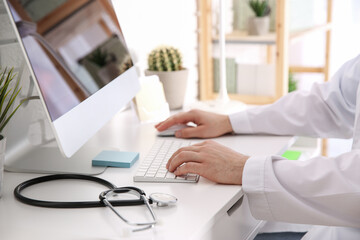 Canvas Print - Doctor working with computer at desk in office, closeup