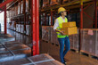 © Mongkolchon - warehouse worker with safety vest and helmet working in warehouse