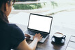 © panitan - computer mockup image blank screen.hand woman work using laptop with white background for advertising,contact business search information on desk at coffee shop.marketing and creative design