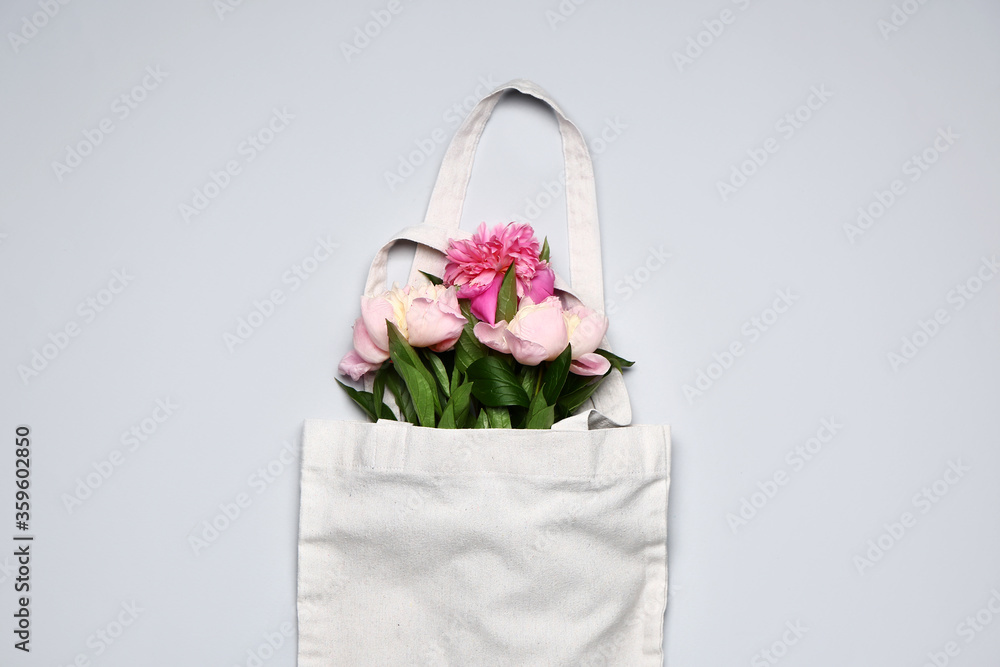 Eco bag with flowers on light background