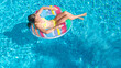 © Iuliia Sokolovska - Acrive girl in swimming pool aerial top view from above, kid swims on inflatable ring donut , child has fun in blue water on family vacation resort