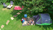 © Iuliia Sokolovska - Aerial top view of campsite from above, mother and daughter having fun, tent and camping equipment under tree, family vacation in camp outdoors concept