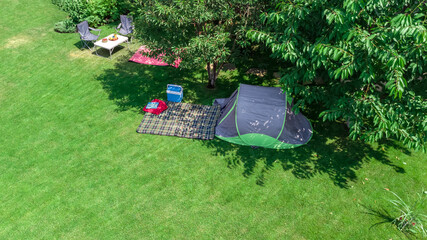 Aerial top view of campsite from above, tent and camping equipment under tree, family vacation in camp outdoors concept 
