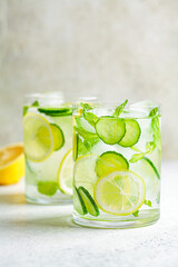 Wall Mural - Detox sassy water with cucumber and lemon in glass, light background. Healthy eating concept.