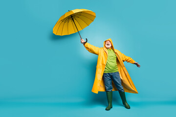 Full length body size view of his he cheerful cheery dreamy grey-haired man wearing yellow topcoat bad cold weather cyclone day isolated over bright vivid shine vibrant blue color background