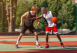 © Prostock-studio - Professional basketball players on outdoor court during friendly game