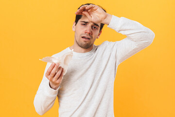 Wall Mural - Photo of sick unhappy man with runny nose posing with tissue on camera