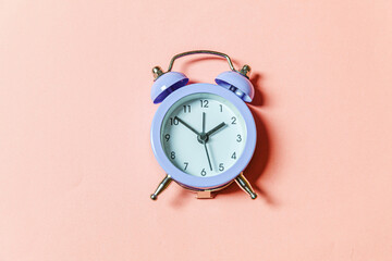 Simply minimal design ringing twin bell vintage classic alarm clock Isolated on pink pastel background. Rest hours time of life good morning night wake up awake concept. Flat lay top view, copy space