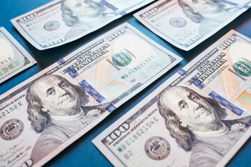 American cash dollars. Hundred-dollar bills in hand on blue background.