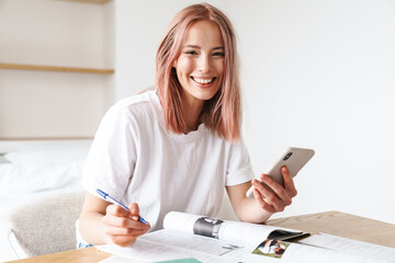 Poster - Image of woman using smartphone while doing homework with exercise books