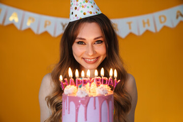 Sticker - Image of delighted young woman showing birthday torte with candles