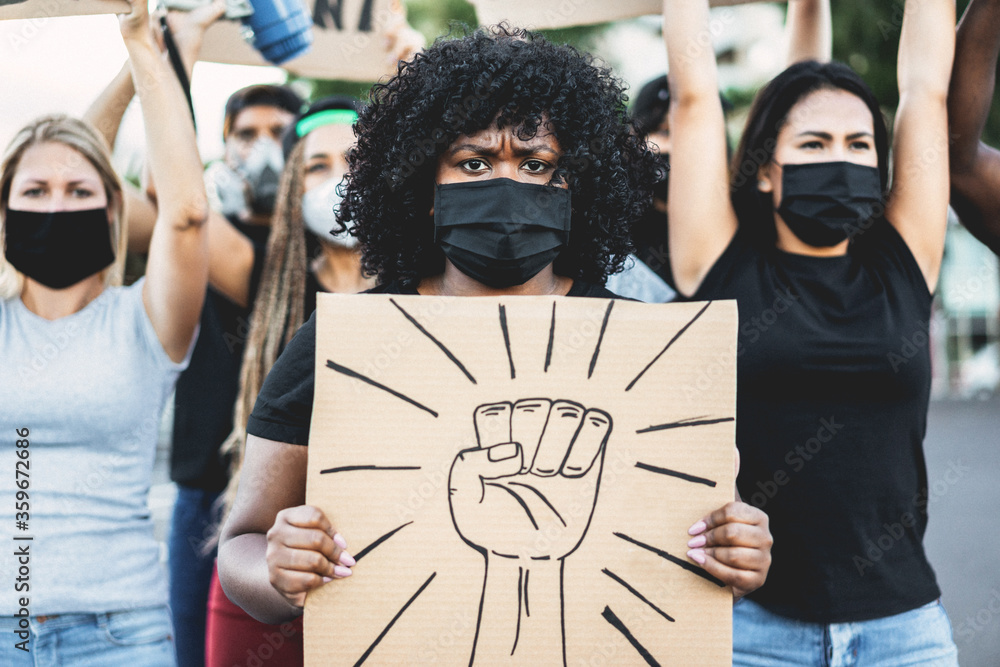 People from different culture and races protest on the street for equal rights with fist banner - Demonstrators wearing face masks during black lives matter fight campaign - Focus on black girl eyes - obrazy, fototapety, plakaty 