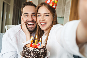 Wall Mural - Cheerful attractive young couple celebrating birthday