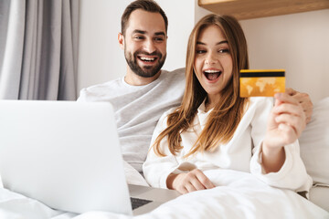 Wall Mural - Lovely young happy couple laying in bed