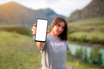 Poster - The woman showing the phone in nature. Mockup phone image. 