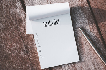 notebook and pen with to do list words on wooden table background.
