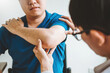 © joyfotoliakid - Physical Doctor consulting with patient About elbow muscule pain problems Physical therapy diagnosing concept
