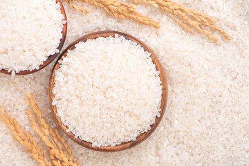 Wall Mural - Raw rice in a bowl and full frame in the white background table, top view overhead shot, close up