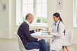 © Studio Romantic - Doctor woman and patient are sitting at a table in the office of a medical clinic.