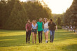 © Studio Romantic - A group of friends have fun walking on the grass in the summer park.