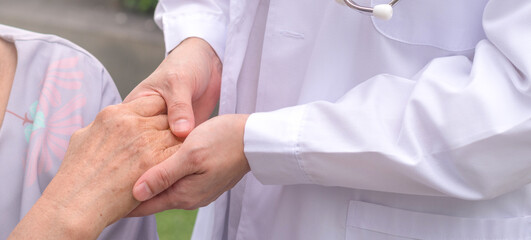 Geriatric doctor or geriatrician concept. Doctor physician hand on happy elderly senior patient to comfort in hospital examination room or hospice nursing home or wellbeing county.