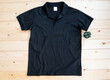 Black male Polo shirt mock up flat lay on wooden background. Top front view