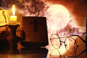 Wall Mural - Vintage glasses on an old retro book on a background of the moon. Reading a book by candlelight. The concept of book thrillers and novels.