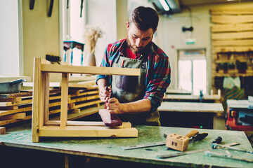 Wall Mural - caucasian craftsman improving decorative chair during woodworking hobby in manufacturing restauratio